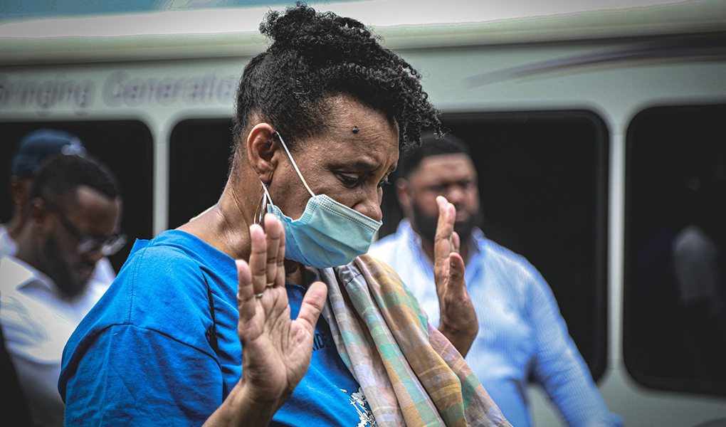 Community members join in pray at an anti-violence rally. 